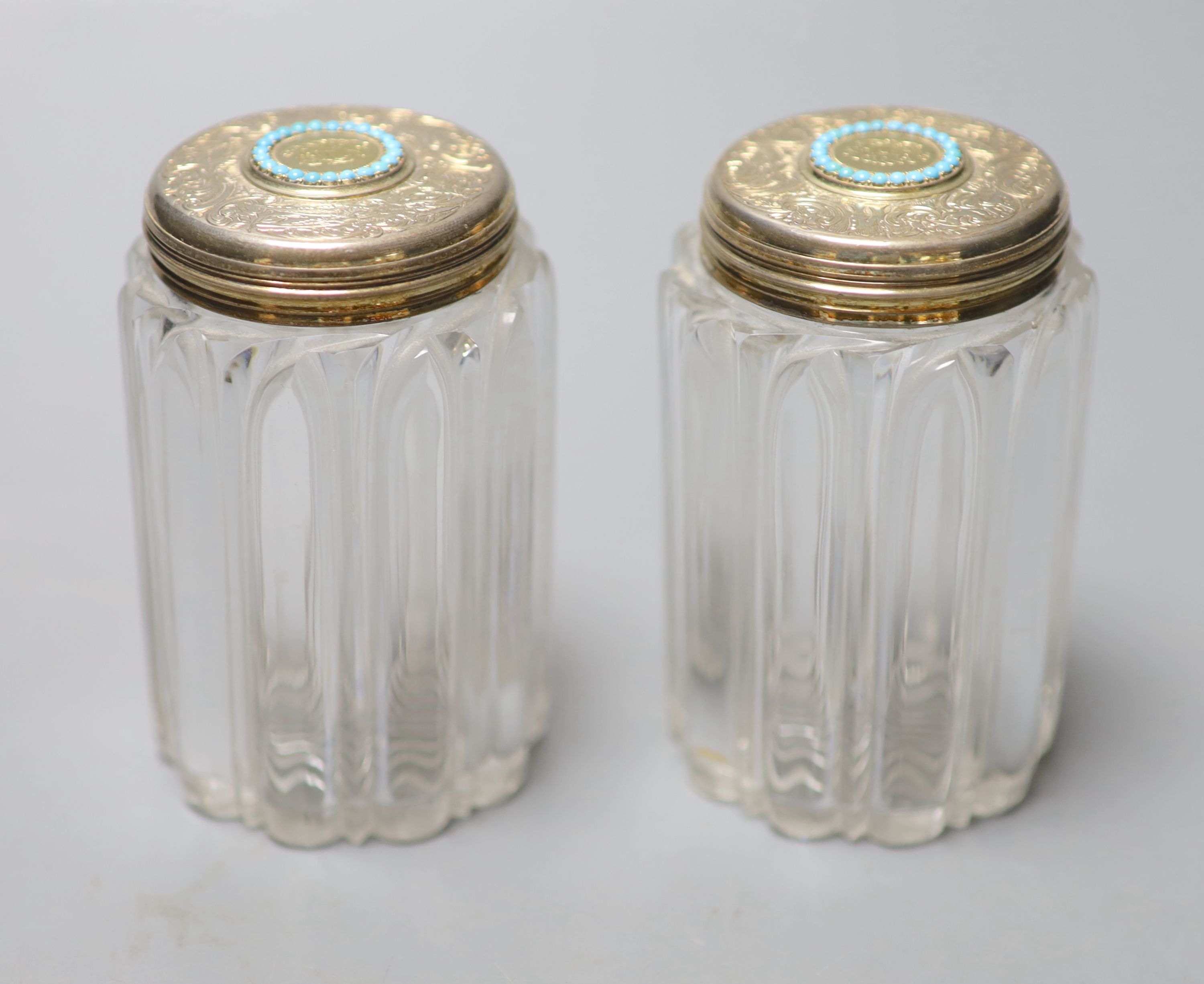 A pair of Victorian silver gilt and turquoise lidded glass cylindrical toilet jars, John Harris, London, 1854, 9.8cm.